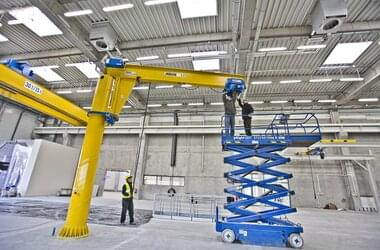 Montage einer Laufkatze an einen freistehenden Schwenkkran in einer Produktionshalle der Firma Rolls-Royce in Polen