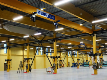 Ein gelber ABUS Kran in einer Produktionshalle von Blueprint Automation (BPA)
