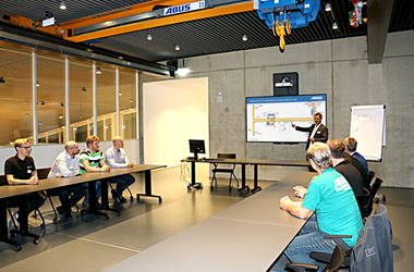 Service-Schulungsraum mit Lauf-Kran und referierendem ABUS Kransysteme GmbH Mitarbeiter und seinen Zuhörern 