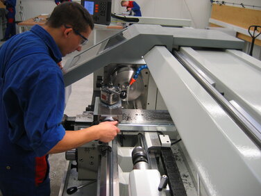 Auszubildender zum Industriemechaniker an einer Bearbeitungsmaschine in Lehrwerkstatt