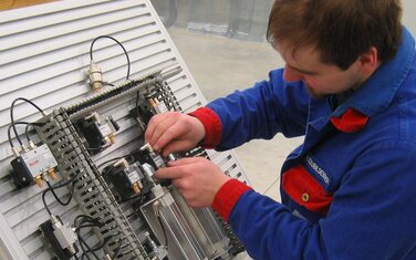 Auszubildender zum Elektroanalagenmonteur installiert elektrotechnische Anlage 