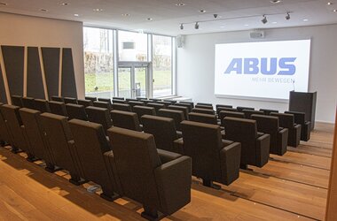 Auditorium mit großer Leinwand und bequemen Sesseln und separatem Ausgang zur Außenanlage