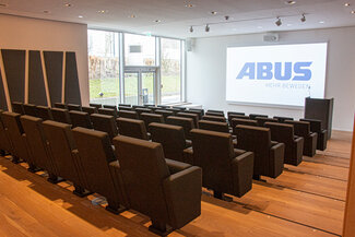 Auditorium mit großer Leinwand und bequemen Sesseln und separatem Ausgang zur Außenanlage
