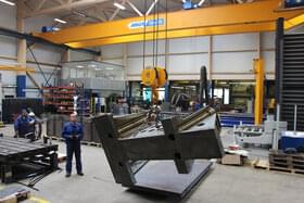 ABUS Zweiträger-Laufkran wird von CFM Schiller Mitarbeiter bedient und hebt tonnenschweres Metall an 