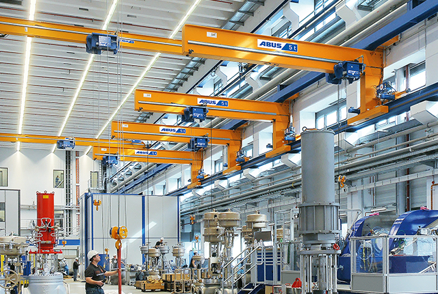 ABUS Wandlaufkrane in einer Industriehalle mit Tragfähigkeit bis 5 t und Spannweite bis 12 m zur effizienten Bedienung mehrerer Arbeitsplätze.